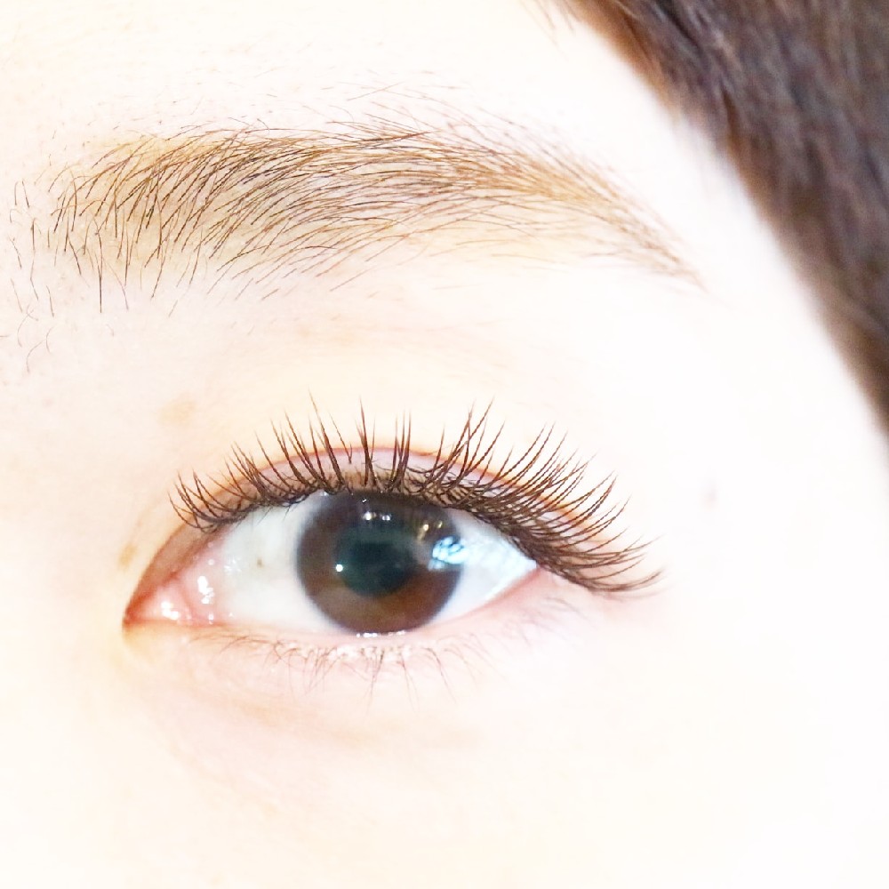 冬の温泉旅行や年末イベントに向けて、ナチュラルでも華やかに見えるまつげエクステをした大人女性の目元。