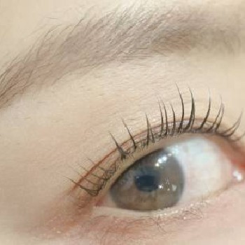 自然な仕上がりのまつげと眉毛が整った40代前後の女性。派手になりすぎず、お顔全体に馴染む自然な印象に整えている様子。